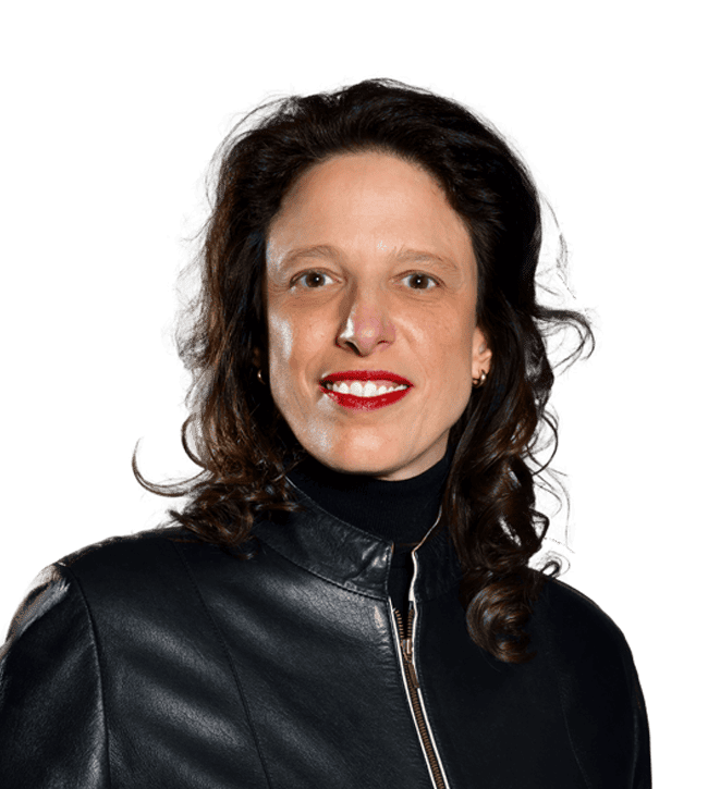 Woman with shoulder-length brown hair wearing a black leather jacket, red lipstick, and a friendly smile at the camera.